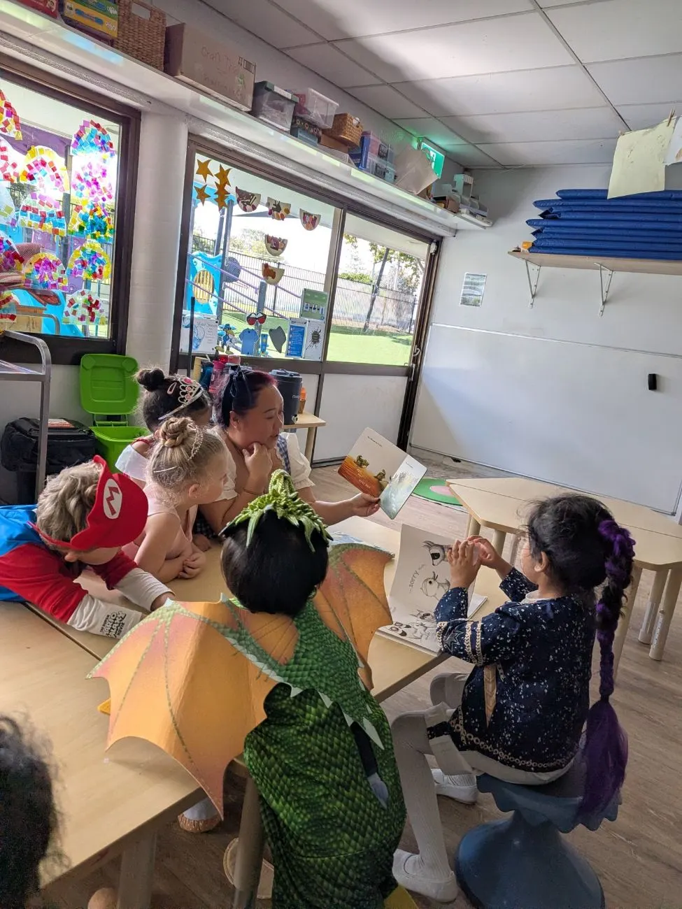 Children in dress-ups listening to a story at the table