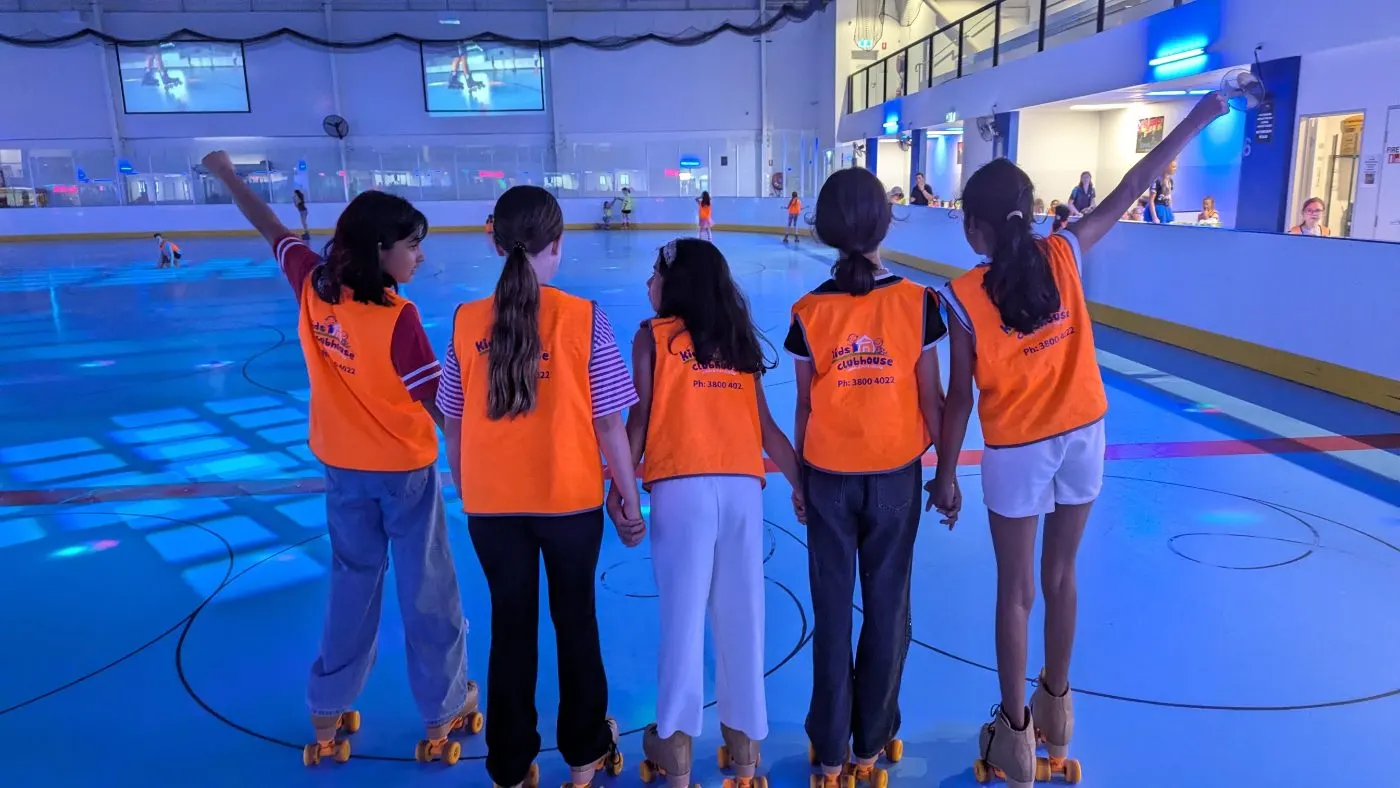 OSHC children in Kids Clubhouse vests holding hands at the roller skating rink